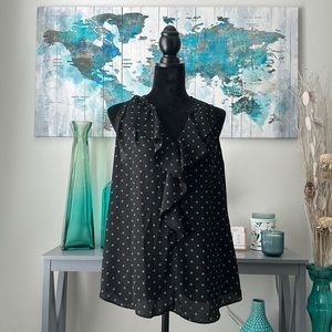 Black shirt with no sleeves with four square design and collar. Zac & Rachel.